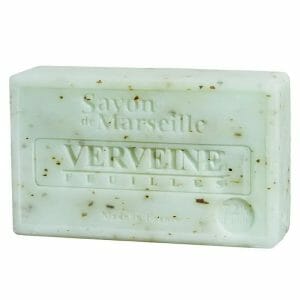 Сапун от светлозелен сапун с кафяви петна, щамповани с „Savon de Marseille Verveine Feuilles“ и „Произведено във Франция“. This Натурален марсилски сапун Листа от върбинка Features verbena leaves for an authentic touch.
