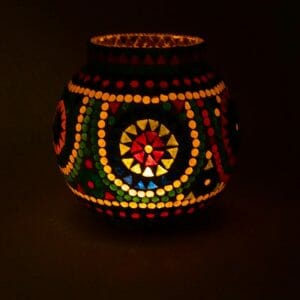 Мозаечен Стъклен Свещник Цветен създава топла, атмосферна светлина в тъмна обстановка със своя осветен, кръгъл дизайн и цветни шарки.