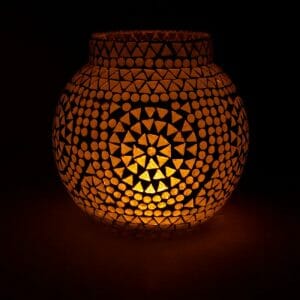 Светещ Мозаечен Стъклен Бял Свещник с шарка от кръгове и триъгълници осветява тъмнината с топла жълта светлина.