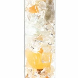 Close-up of a glass vial filled with small, polished, transparent, and yellowish скъпоценни камъни neatly arranged and connected from the Пръчица за пречистване на вода със скъпоценни камъни "Подреждане и свързване".