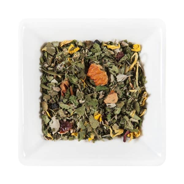 Квадратна бяла чиния, пълна с насипна смес от билков чай Ураган, показваща асортимент от зелени листа, сушени цветя и парчета портокал.