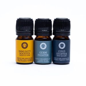 Показани са три бутилки от Комплекта за ароматерапия с етерични масла Wellness: Immunity Booster, Germ Fighter и Cold Stopper, всяка с уникални цветни етикети. Идеален за вашата рутинна ароматерапия и насърчаване на цялостното здраве.